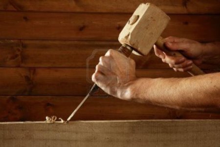 6767510-gouge-wood-chisel-carpenter-tool-hammer-in-hand-working-wooden-background.jpg